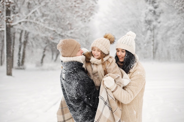 Mother and her little daughter playing outdoors at winter day