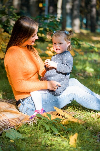 Mother and her little girl in autumn park