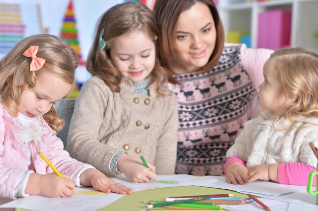 Photo mother and her three daughters drawing together