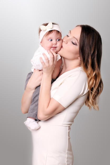 Mother holding baby in bedroom in cozy weekend morning