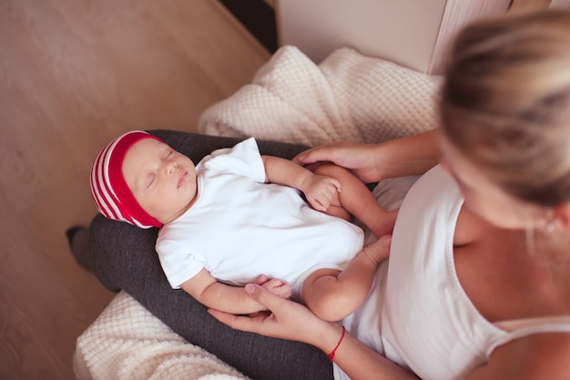 Mother holding baby boy sleeping on her hands in room Motherhood Maternity