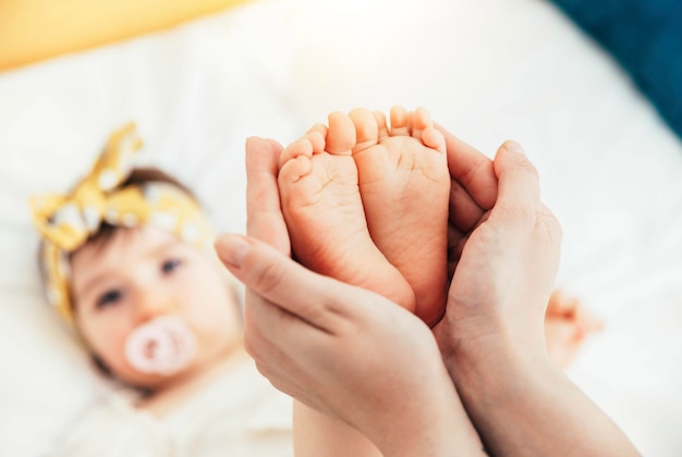 Mother holding baby feet Happy family concept