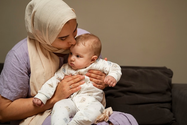 Foto vista frontale del bambino della holding della madre