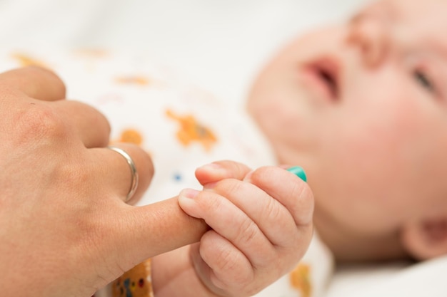 Mother holding a baby`s hand in her hand