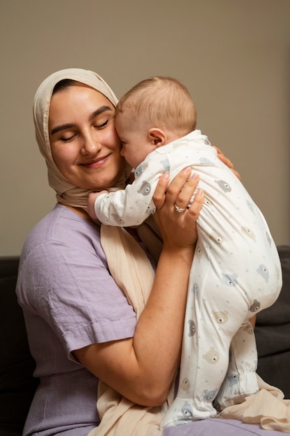 Photo mother holding baby side view