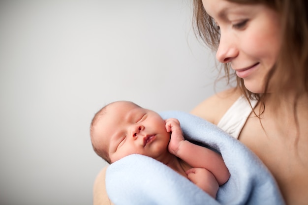 Mother holding  baby wrapped in blanket