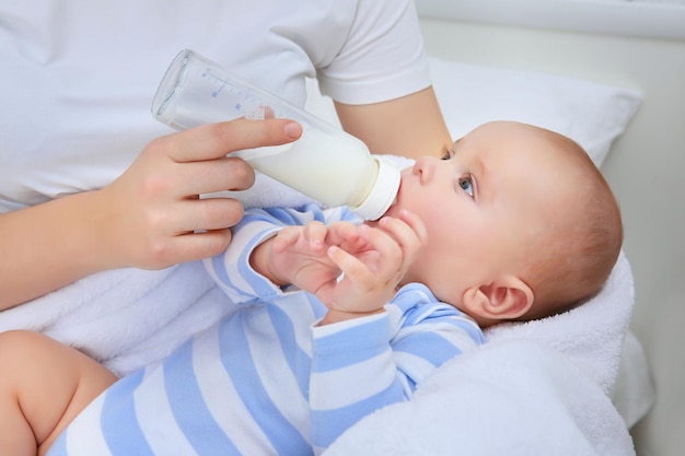 Mother holding and feeding baby from bottle