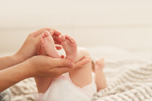 Mother holding feet of baby