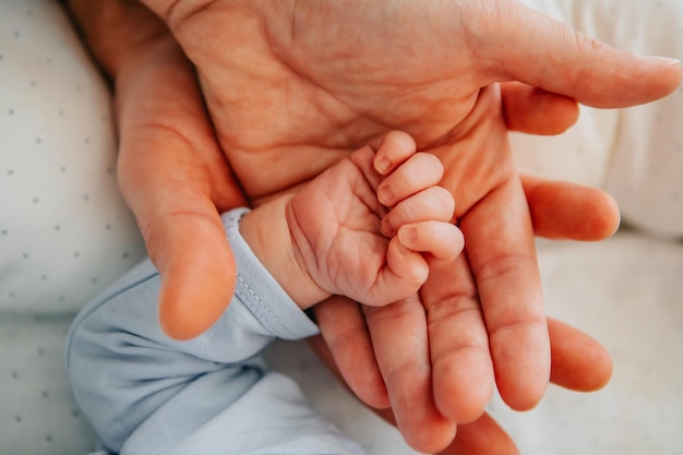 Mother holding a hand of a newborn baby