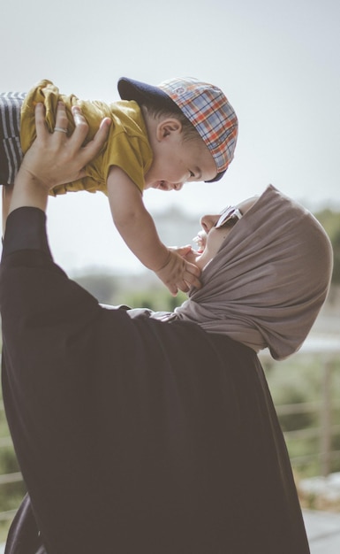 A mother holding her baby in the air