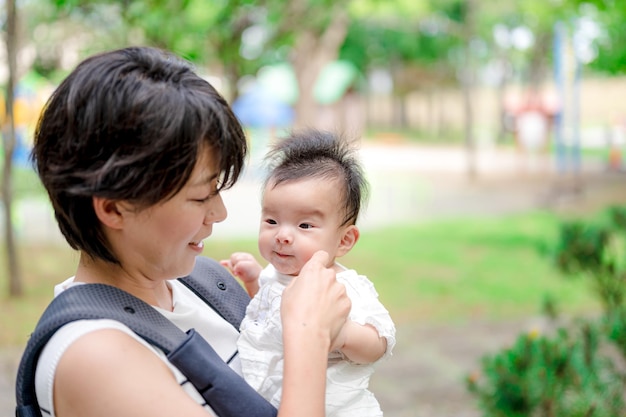 A mother holding her baby in a carrier