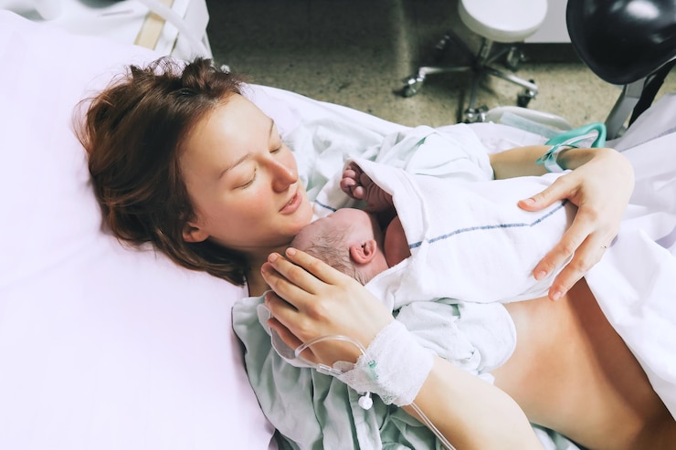 Mother holding her newborn baby child after labor in a hospital Mother giving birth to a baby boy