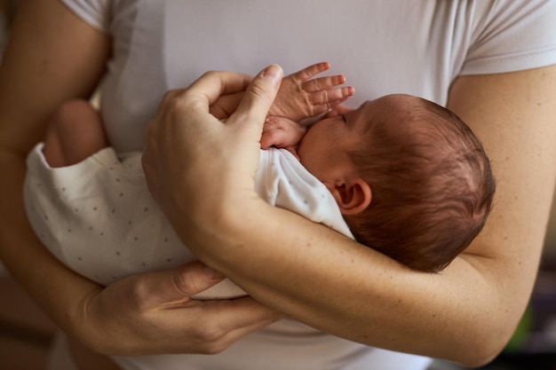 Mother holding her newborn baby in hands