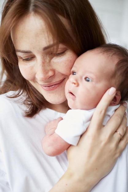 Mother holding her newborn baby Home portrait of newborn baby and mother Enjoying time together