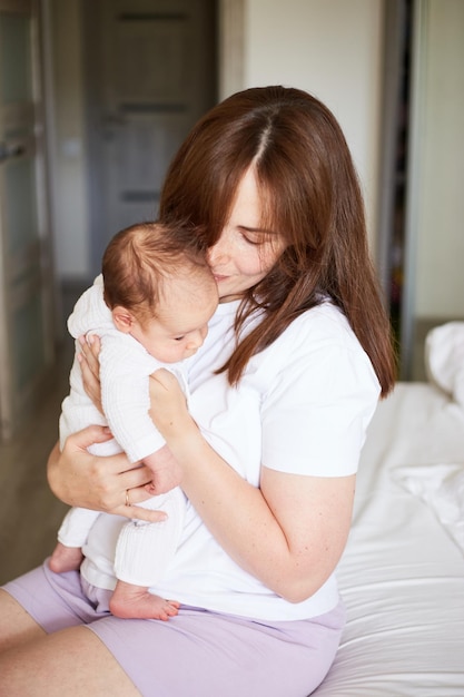 Mother holding her newborn baby Home portrait of newborn baby and mother Enjoying time together