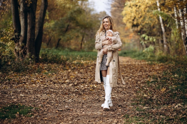 Mother holding her newborn child and walking in park