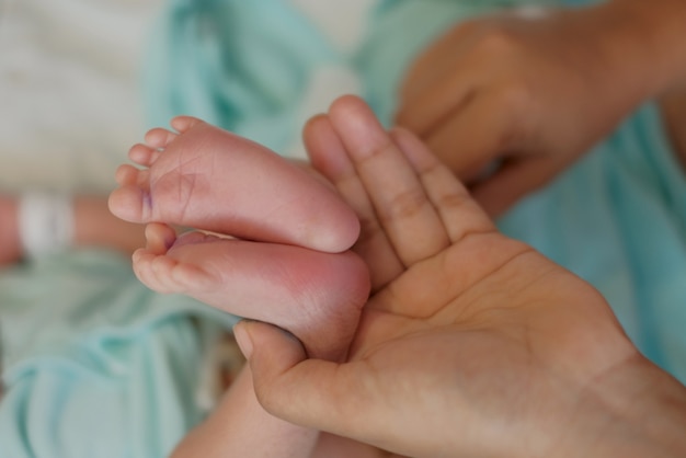 Photo mother holding newborn baby feet