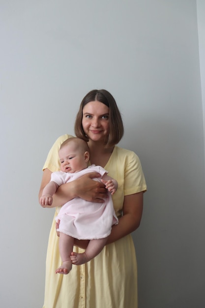 mother holding a newborn baby girl of four months