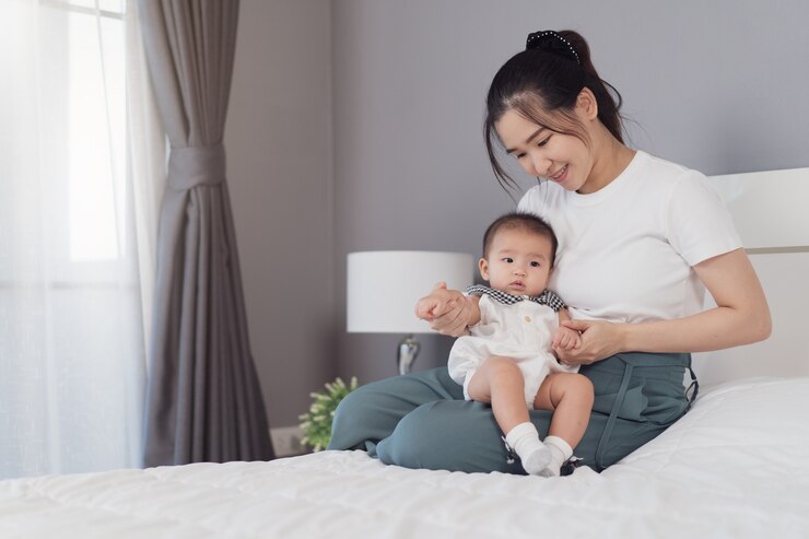 침대에 부드러운 포옹에 신생아를 안고 어머니