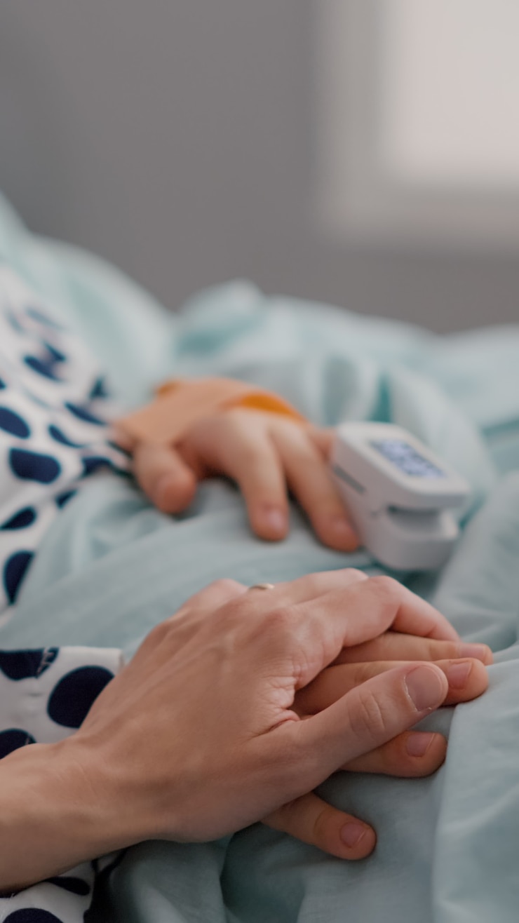 Photo mother holding sick daughter hands after sufffering medical surgery during recovery examination