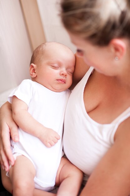 Mother holding sleeping baby on hands