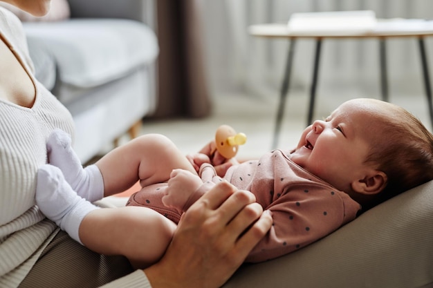 Photo mother holding smiling infant on lap