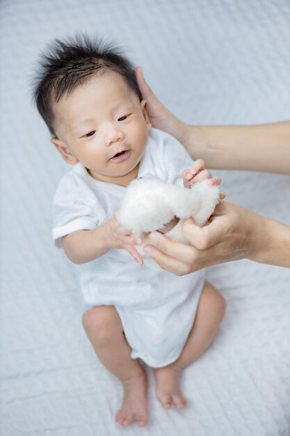 Photo mother holding a toy to little baby