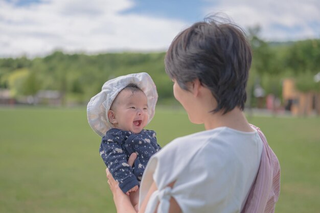 公園で赤ちゃんを抱く母親