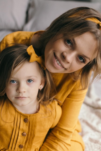 A mother holds her daughter in her arms and admires a narcissus flower