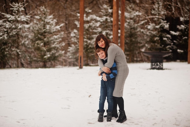 Mother hug son in winter day spending time together