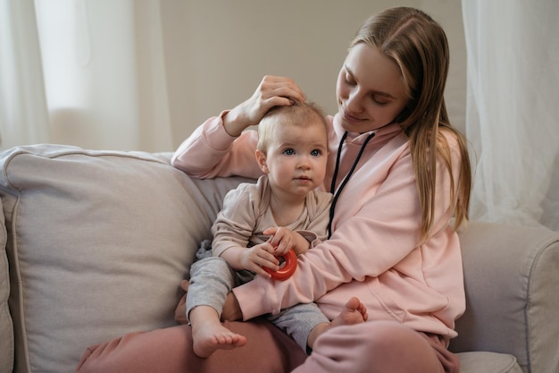 Photo mother hugging baby child sitting on sofa portrait of happy family at home love and care concept