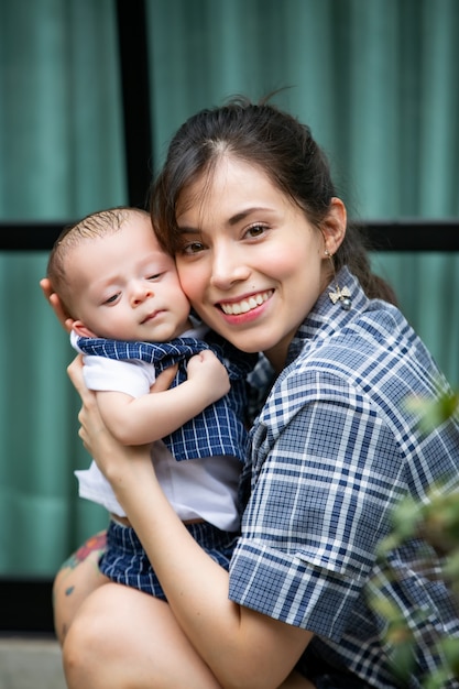 Madre che abbraccia il suo bambino tra le braccia