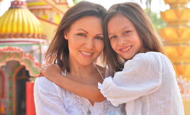 Mother hugging her cute little daughter on seashore