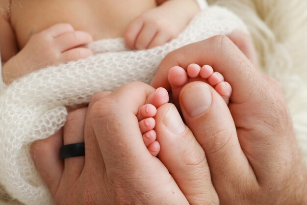 Mother is doing massage on her baby foot closeup baby feet in mother hands prevention of flat feet development muscle tone dysplasia family love care and health concepts studio macro