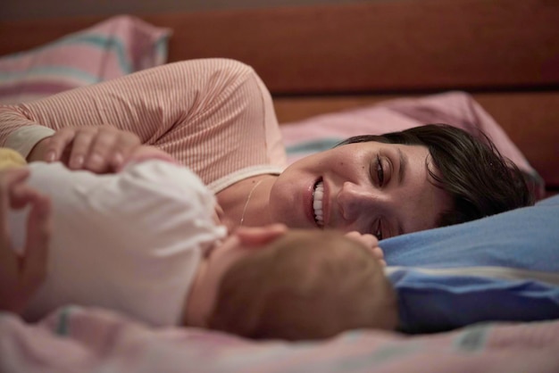 mother is playing with newborn baby at home