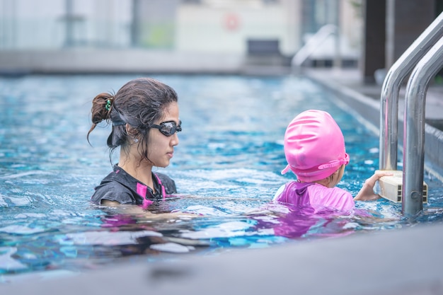 Mother is teaching her daughter to swim