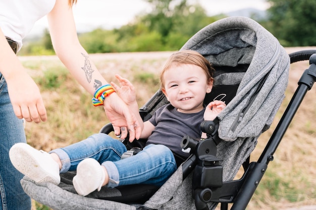 Mother next to a kid sitting in a baby carriage