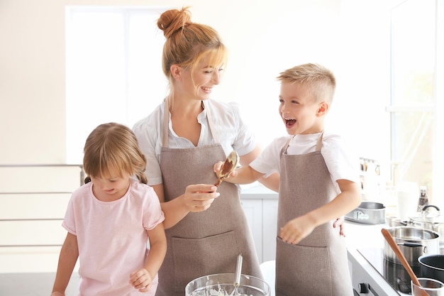 キッチンで生地を作る母と子供たち