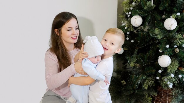 Mother and kids near Christmas tree