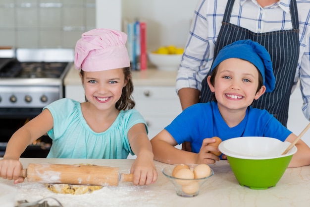 Madre e bambini che preparano cibo in cucina