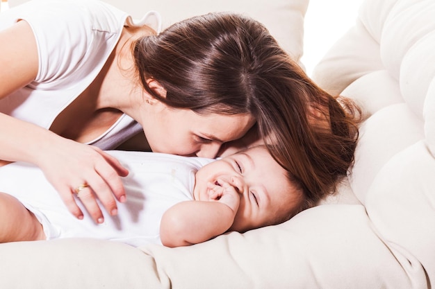 Mother kisses and hugs her child, close up portrait