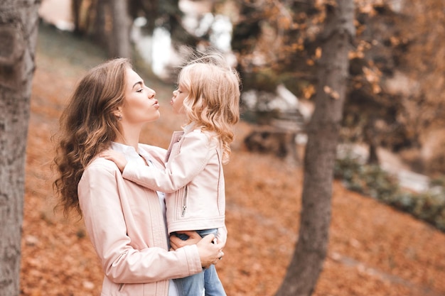 Mother kissing baby girl outdoor