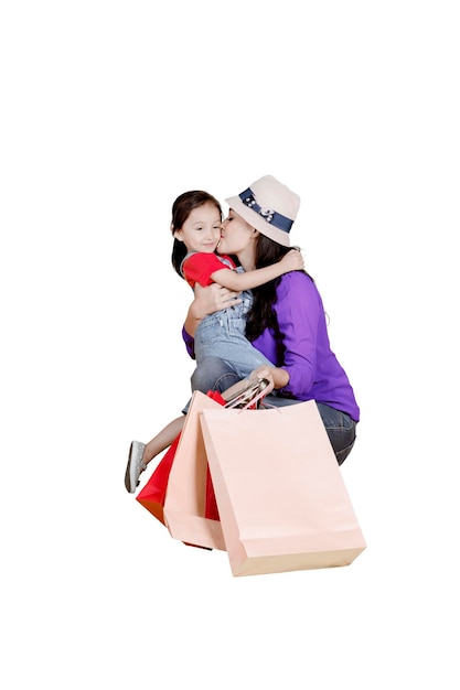 Photo mother kissing daughter over white background