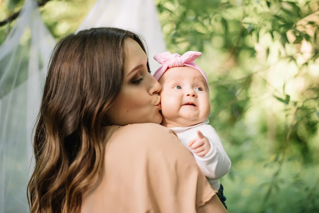 Mother kissing her little baby, girl closeup. Baby on her mom hand.  Love family prople concept.