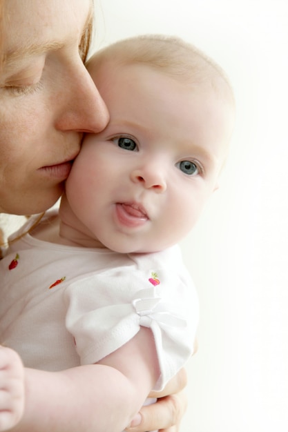 Madre che bacia piccolo bambino sorridente