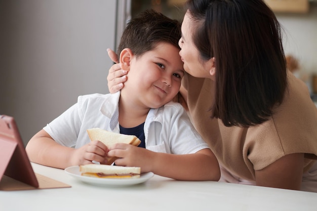 笑顔の息子にキスする母