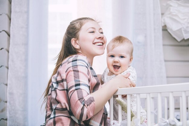 La mamma e il bambino sono nella culla svegliati la mattina e sorridenti a casa