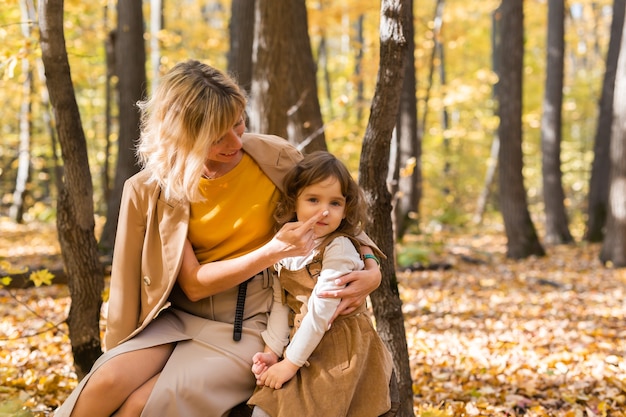 Mother and little daughter enjoying nice autumn day in a park season family and children concept