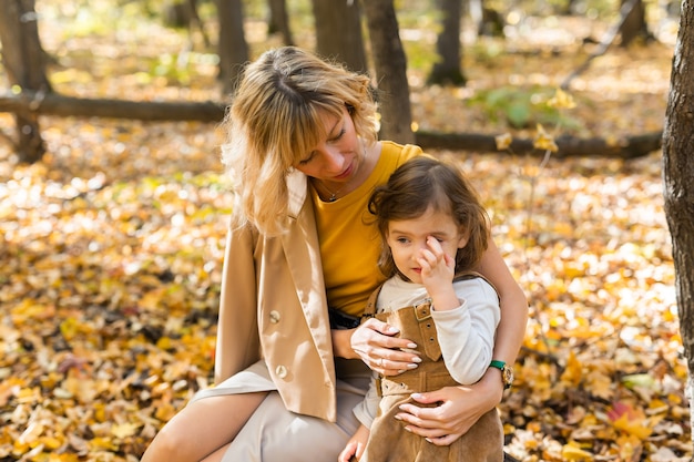 Mother and little daughter enjoying nice autumn day in a park season family and children concept