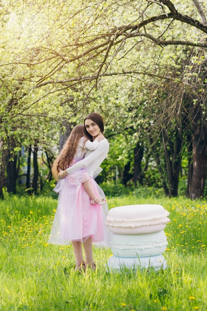 Mother and a little daughter walk in the spring blooming Apple